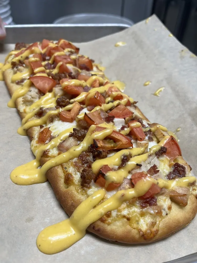 Roman Flatbread Made with Olive Oil Mozzarella Cheese Tomatoes Bacon & Garlic Parm Sauce
